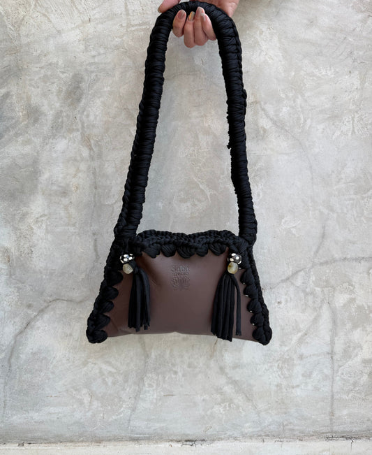 Solara shoulder bag photographed against a natural grey wall, full view