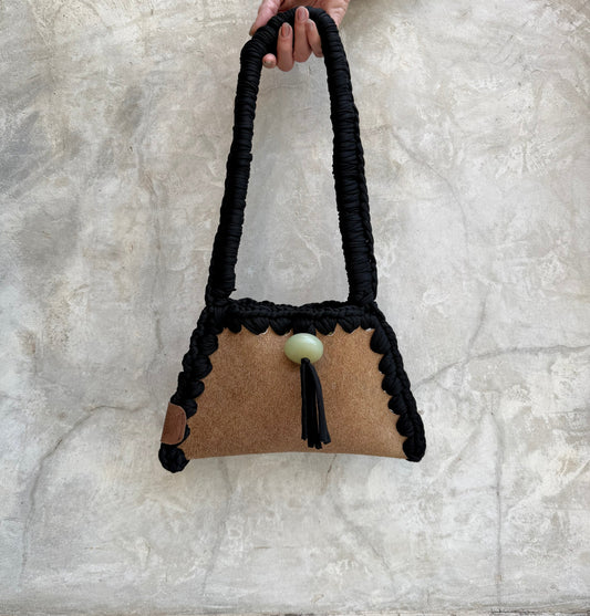 Solara shoulder bag photographed against a natural grey wall, full view