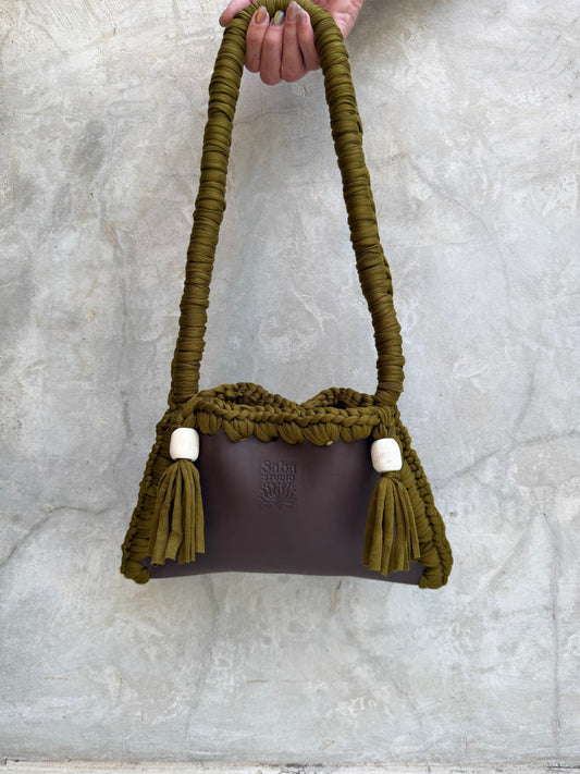 Solara shoulder bag photographed against a natural grey wall, full view