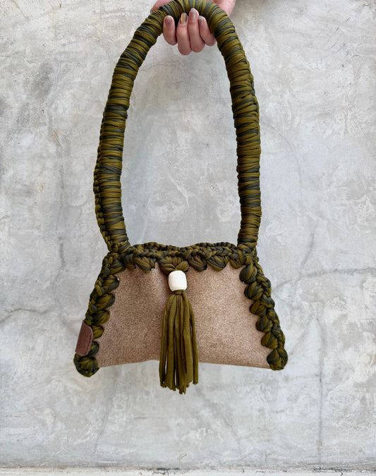 Solara shoulder bag photographed against a natural grey wall, full view