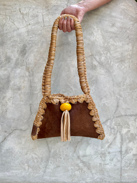 Solara shoulder bag photographed against a natural grey wall, full view